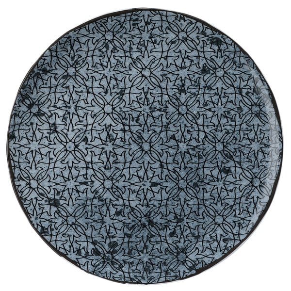 A Schonwald Shabby Chic stone porcelain coupe plate with blue and black ornaments on it.