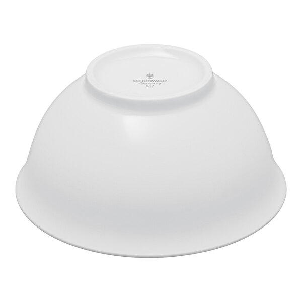 A white porcelain bowl shown upside down on a plain background.