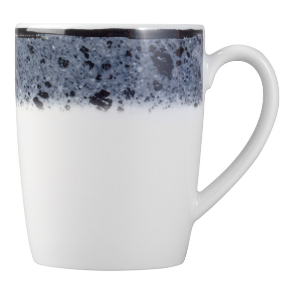 A white porcelain mug with a handle, featuring a speckled dark blue and black band around the top.