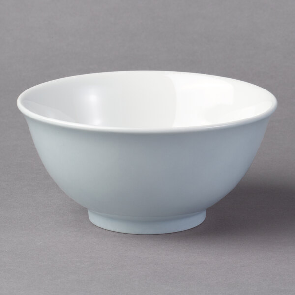 A light blue Schonwald porcelain bowl with a white rim on a gray surface.