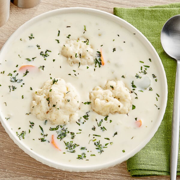 A bowl of Campbell's cream of celery soup with food in it.