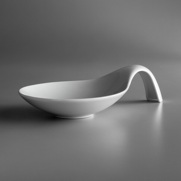 A close-up of a Schonwald white porcelain spoon-shaped bowl with a curved handle.
