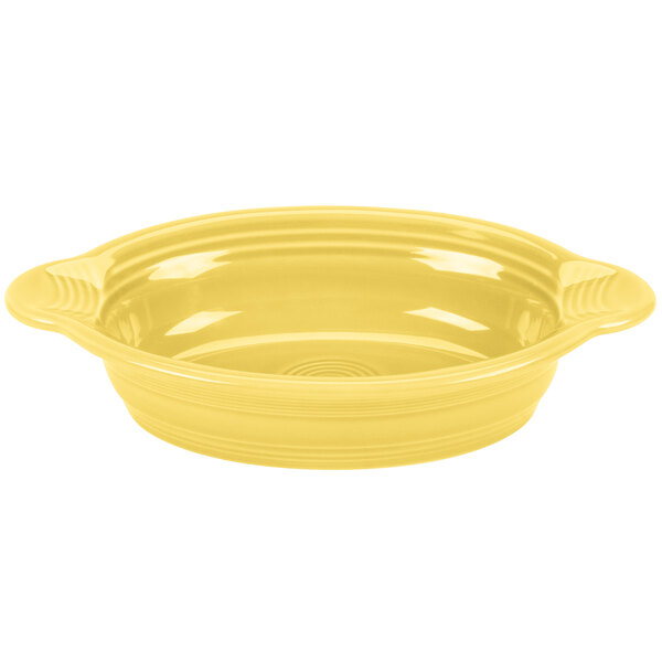 A yellow oval casserole dish with handles on a white surface.