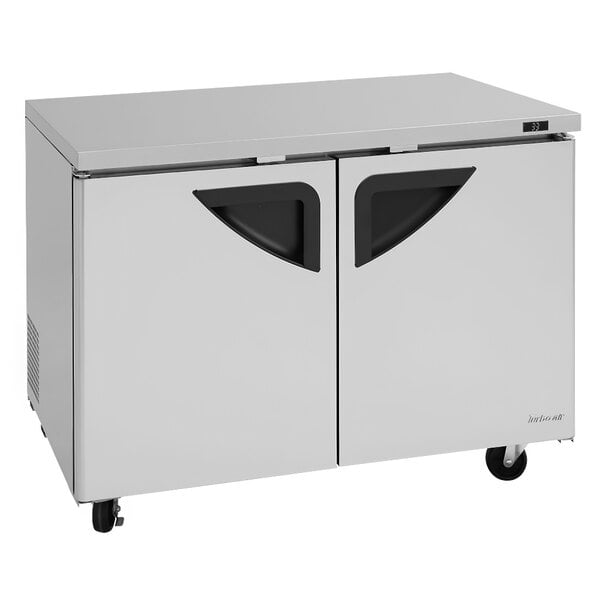 A white stainless steel Turbo Air undercounter refrigerator with black handles on two doors.