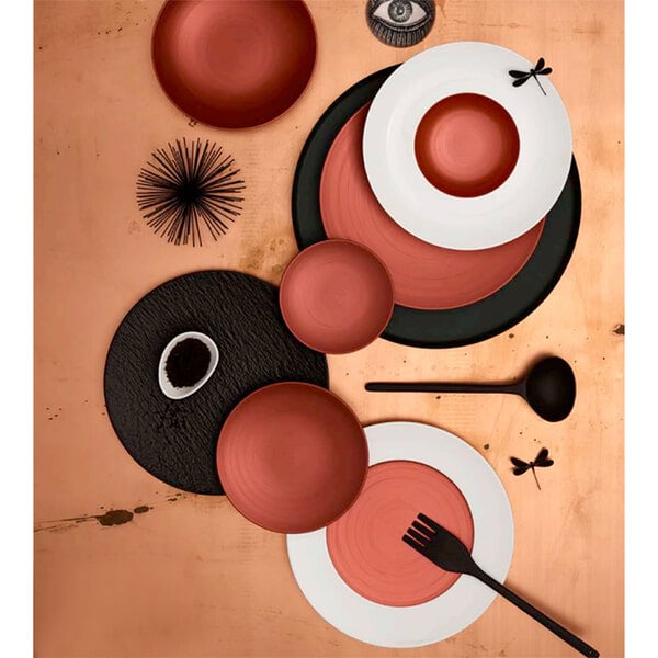 A red Villeroy & Boch Copper Glow porcelain plate on a table with a fork.