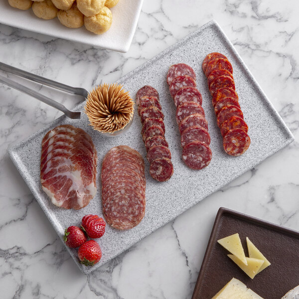 A G.E.T. Enterprises Bugambilia rectangular metal tray with a rim holding sliced salami and cheese.