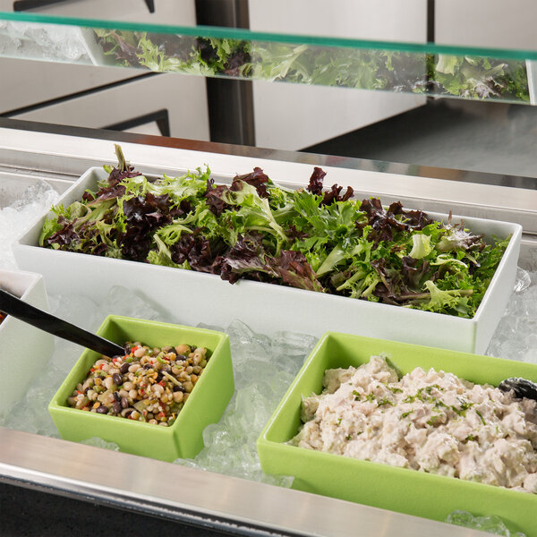 A white G.E.T. Enterprises Bugambilia straight-sided rectangular salad bowl filled with salad on a salad bar counter.