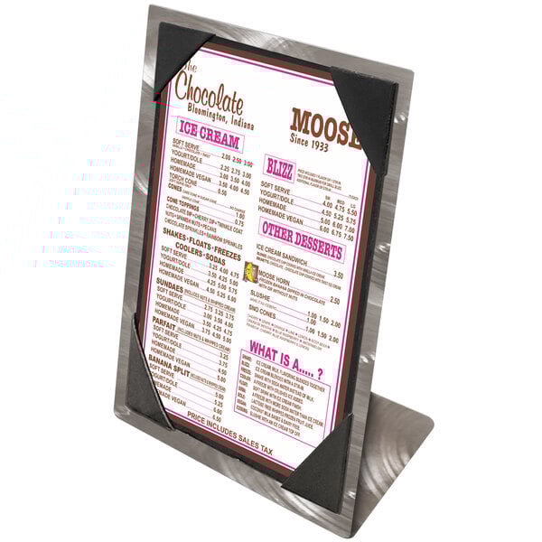 An Alumitique aluminum table tent with swirl picture corners holding a menu on a counter.
