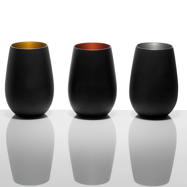Three matte black and gold Stolzle Glisten stemless wine glasses on a white surface.