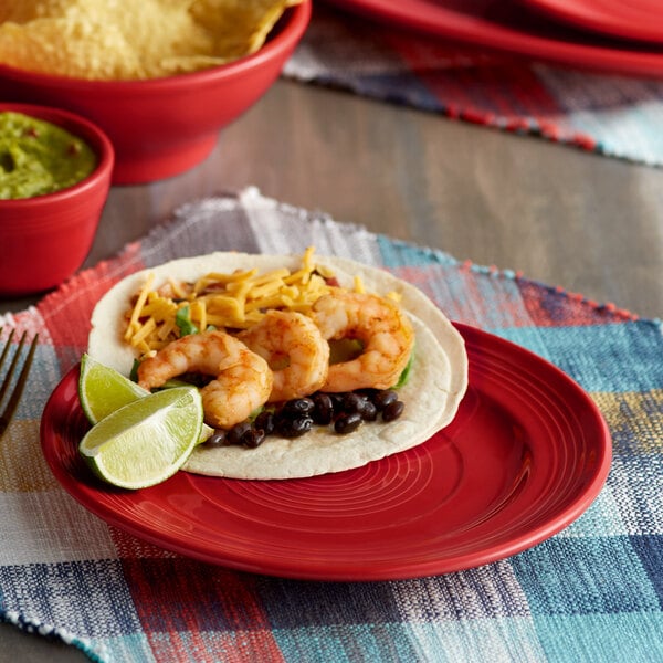 A Tuxton Concentrix cayenne plate with shrimp tacos, black beans, and guacamole.