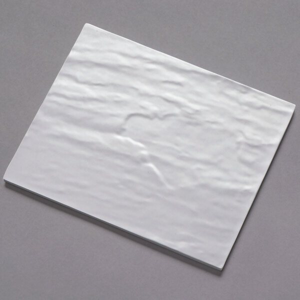 A white rectangular American Metalcraft faux slate melamine platter on a gray surface.