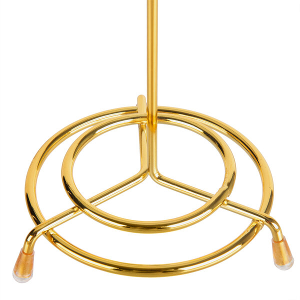 A gold metal Vollrath check spindle on a round base.