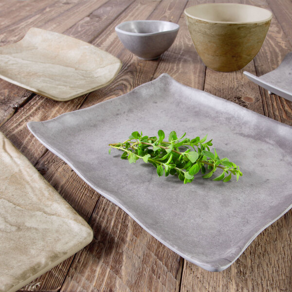 An Elite Global Solutions rectangular melamine tray in Silverstone with a plant on it.