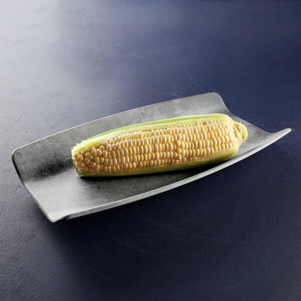 An ear of corn on the cob on a rectangular metal tray.