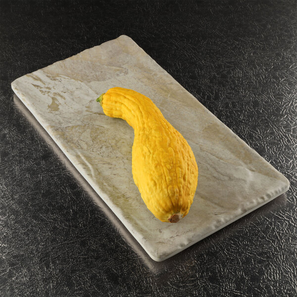 a yellow squash on a white surface