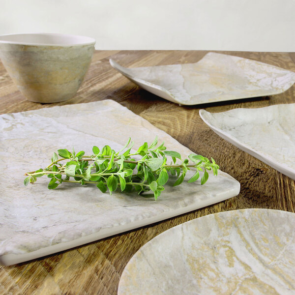 A white rectangular tray with a plate and bowl on a wooden table with a plant.