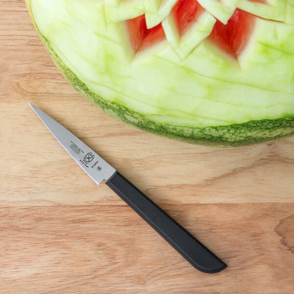 Stamped knife on cutting board next to watermelon