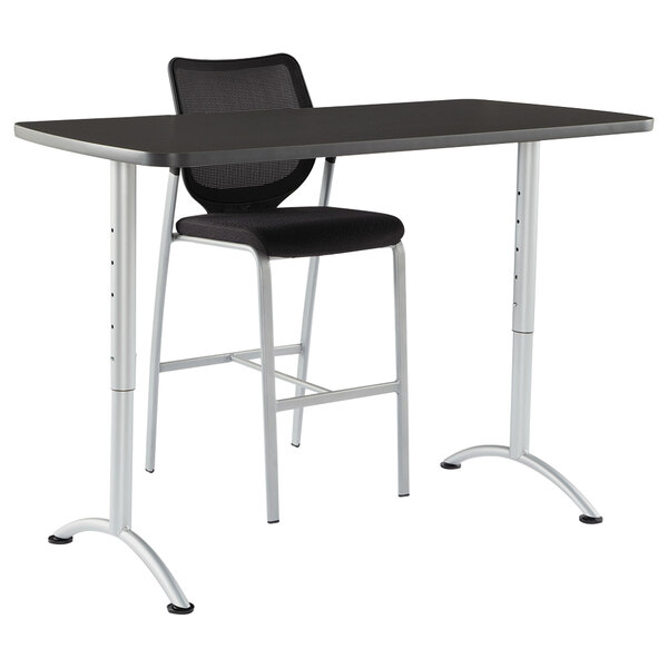 A black desk and chair with silver legs.