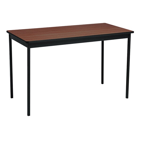 A Barricks walnut utility table with a black frame.