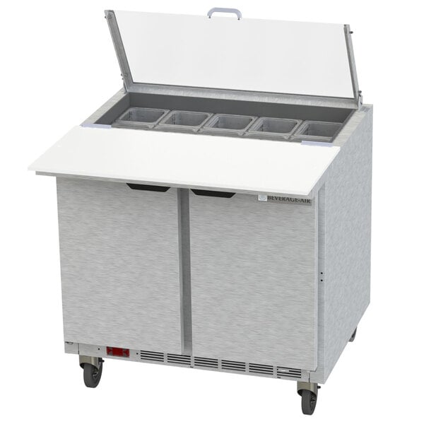 A Beverage-Air stainless steel refrigerated sandwich prep table with clear lids on a counter.