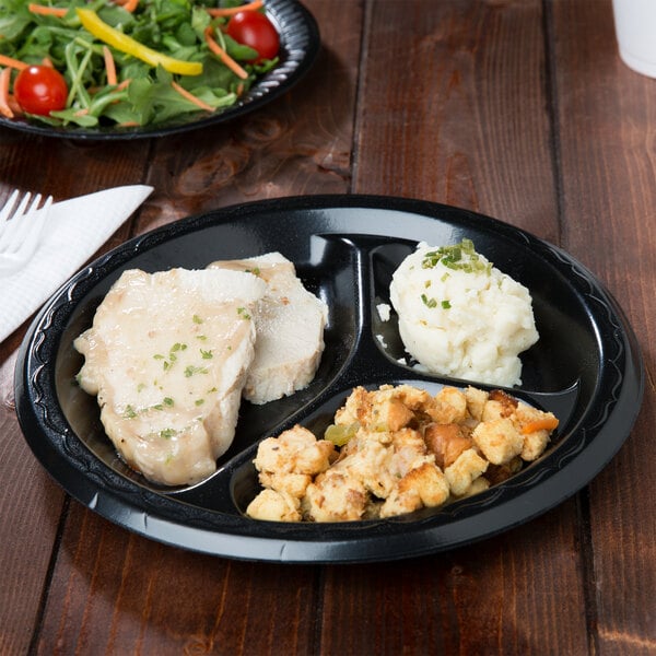 Roast chicken with stuffing and mashed potatoes on a three-compartment black foam plate