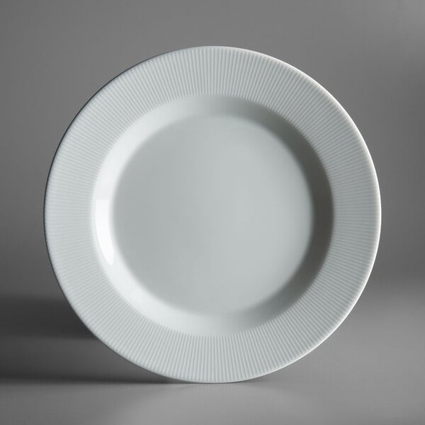 A close-up of a Schonwald white porcelain plate with a ribbed rim.