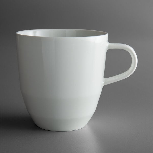 A Schonwald bone white porcelain tall cup with a handle.