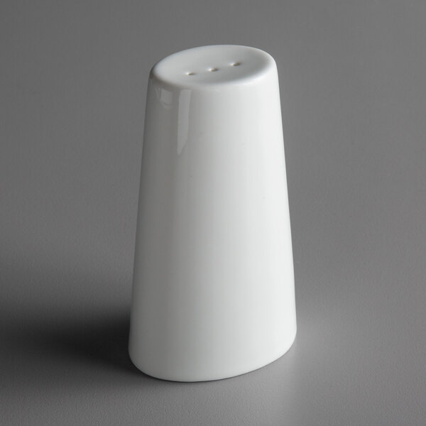 A white porcelain pepper shaker on a gray surface.