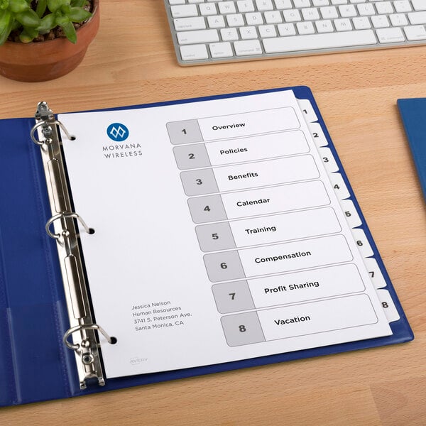 A blue binder with Avery white papers and a list of numbers on it.