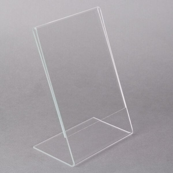 A clear, angled acrylic display stand with a rectangular shape, positioned on a gray background.