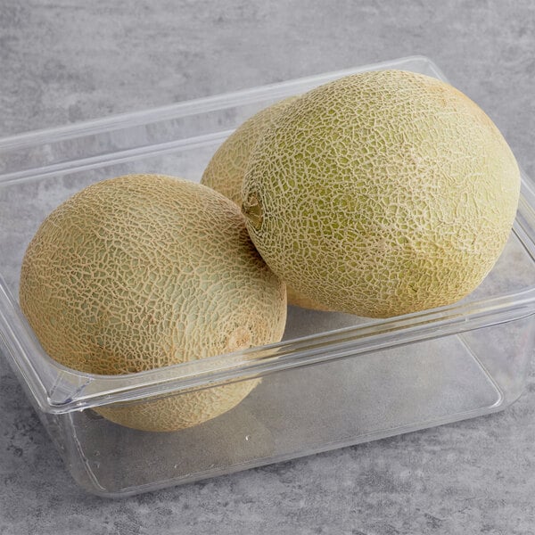 A clear container of Cantaloupe melons.