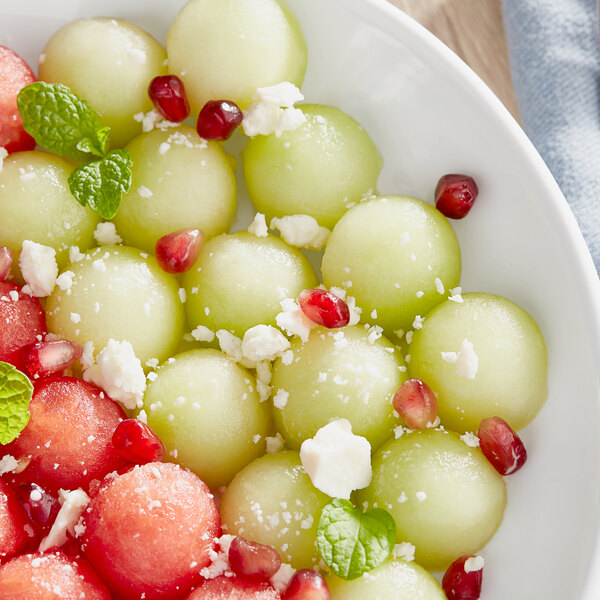 A close up of a green honeydew melon with white cheese.