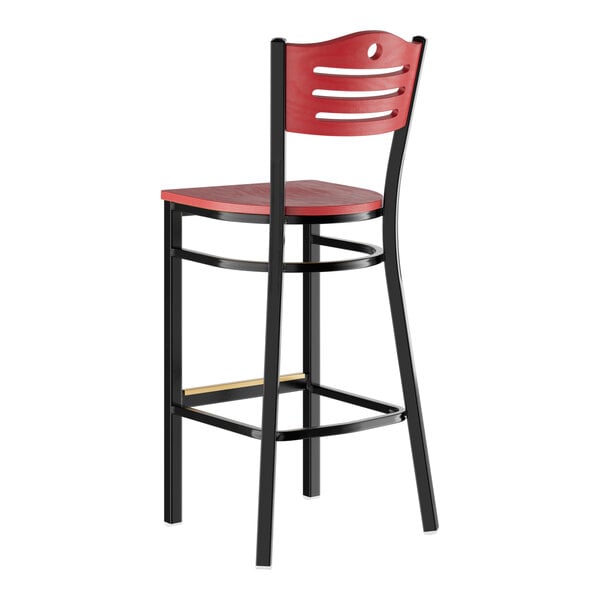 A bar stool with a mahogany wood seat and backrest, featuring a black metal frame and a slatted back design.