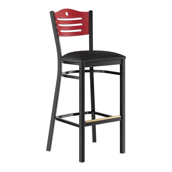 A bar stool with a black padded seat, black metal frame, and a mahogany-colored wooden backrest featuring horizontal cutouts.