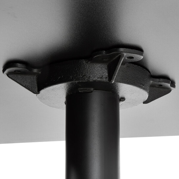 A black metal pole with a black base on a Lancaster Table & Seating bar table.
