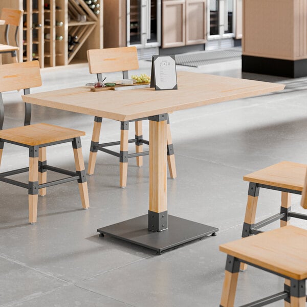 A rectangular solid wood live edge table top with a bleached oak finish, supported by a central metal base, shown with matching chairs in a modern dining setting.