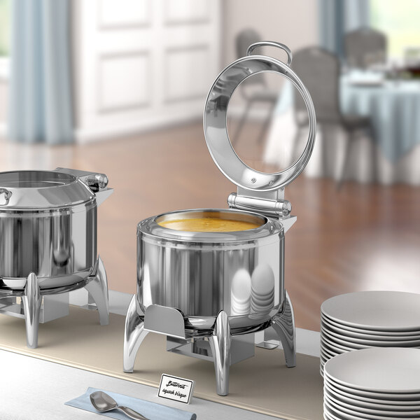 A buffet table with an Acopa stainless steel soup chafer on a stand.