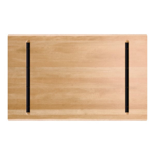 A rectangular wooden tabletop with a light honey maple finish and two parallel black metal support bars on the underside.