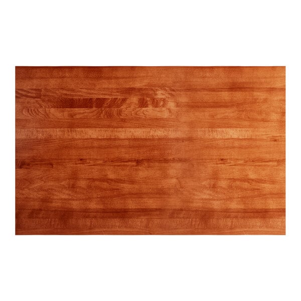 A close up of a Lancaster Table & Seating solid wood table top with a rustic mahogany finish.
