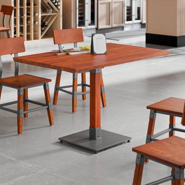 A rectangular solid wood live edge table top with a rustic mahogany finish, supported by a metal base.