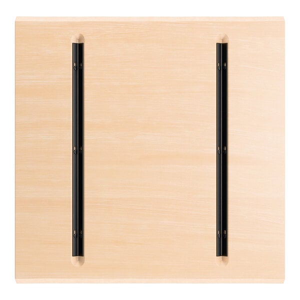 A square wooden panel with a light bleached oak finish, featuring two parallel black metal strips attached vertically.