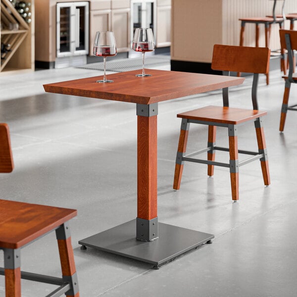 A Lancaster Table & Seating live edge wood table with two wine glasses on it.