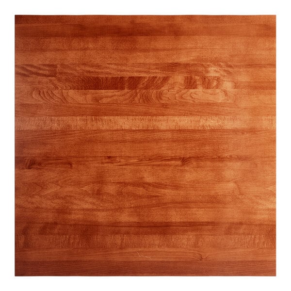 A Lancaster Table & Seating rustic mahogany wood table top with a live edge.