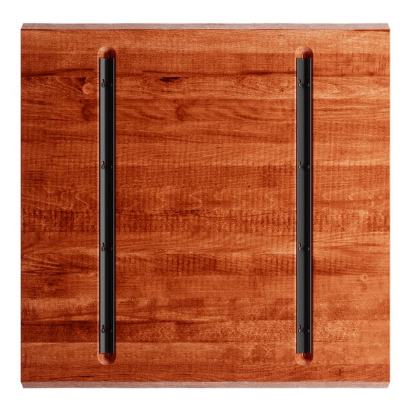 A Lancaster Table & Seating live edge wood table top with a rustic mahogany finish and black metal bars.