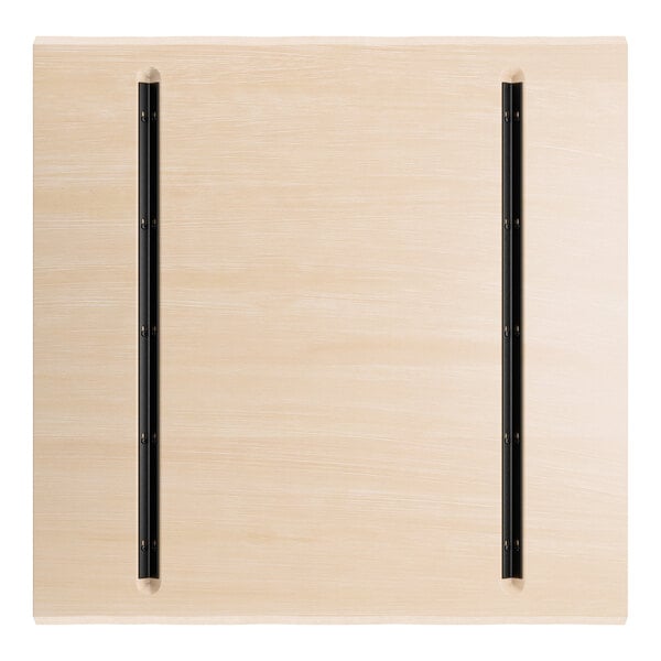 A square wooden surface with a light bleached oak finish and two parallel black metal strips running vertically.