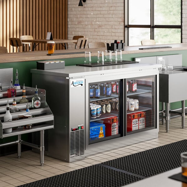 An Avantco stainless steel back bar refrigerator on a counter with bottles inside.