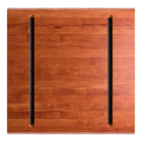 A square wooden tabletop with a rich mahogany finish and two parallel black metal strips running vertically.