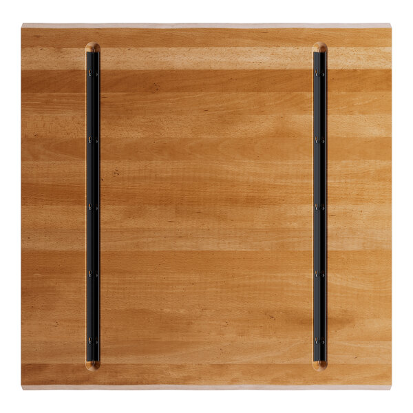 A Lancaster Table & Seating solid wood live edge table top with a honey maple finish and black metal bars.