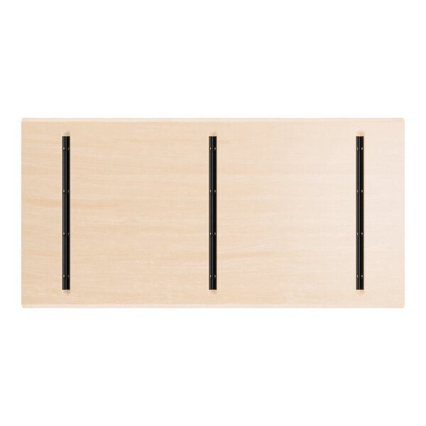 A rectangular, light wood table top with three parallel black metal strips running lengthwise.