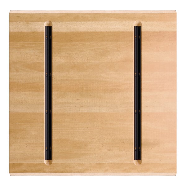 A square wooden tabletop with a honey maple finish and two parallel black metal strips attached lengthwise.